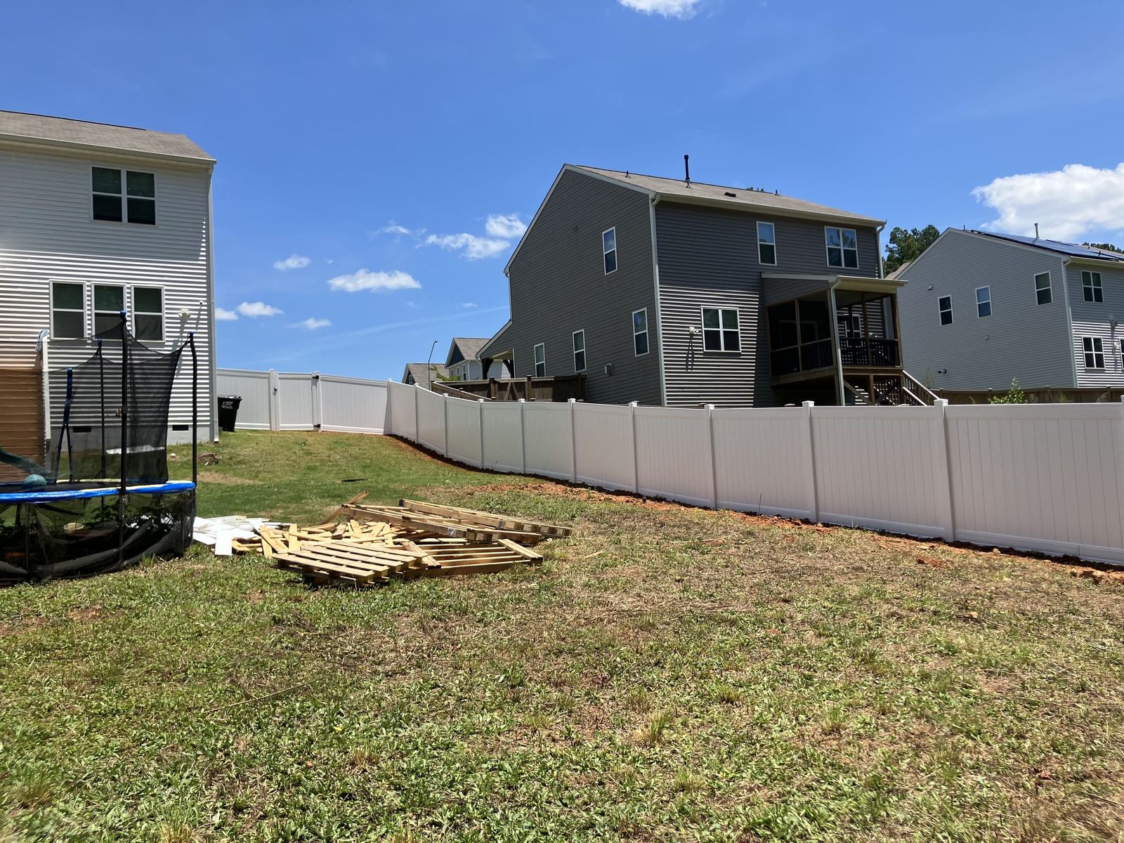 White vinyl privacy fence across a suburban backyard