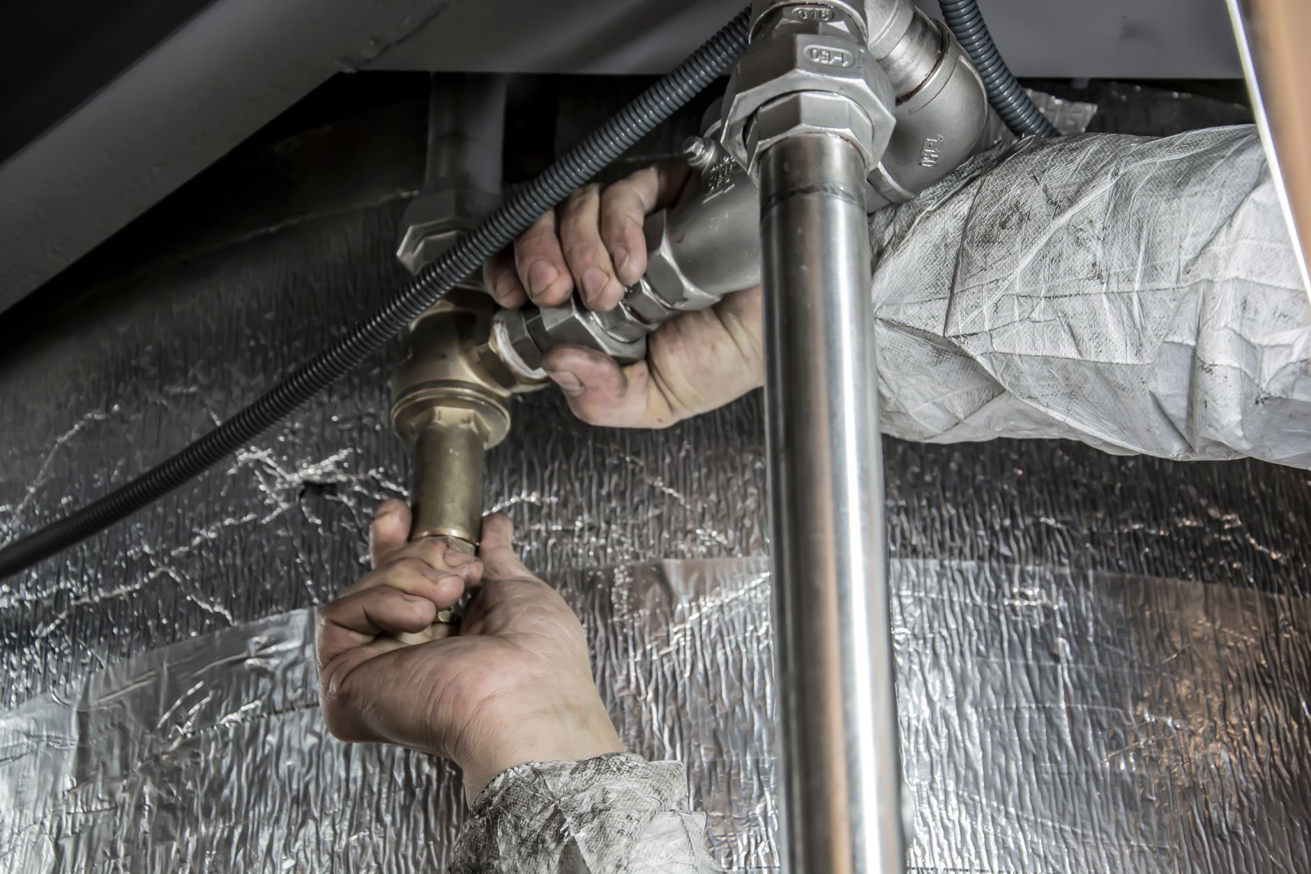 Hands insulating a water supply pipe